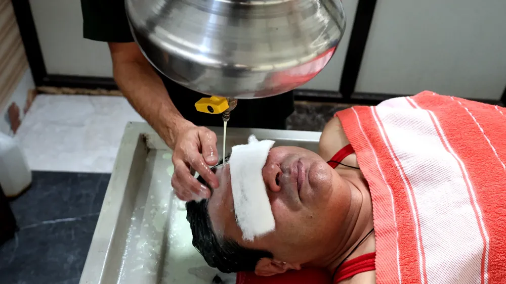 Shirodhara warm medicated oil therapy on the forehead